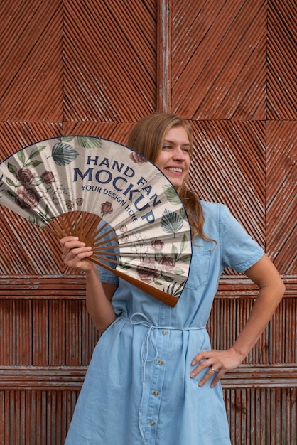 PSD woman holding hand fan with mock-up design