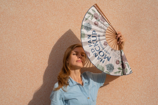 PSD woman holding hand fan with mock-up design