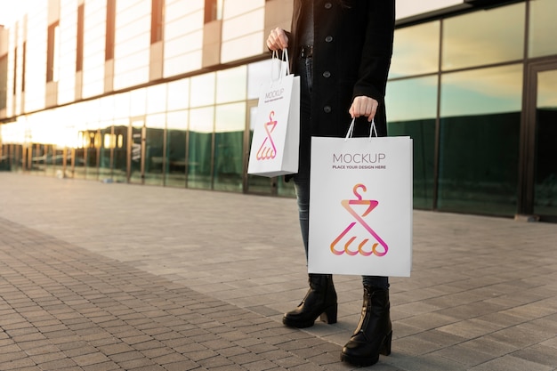 Donna che tiene la lussuosa borsa della spesa all'aperto