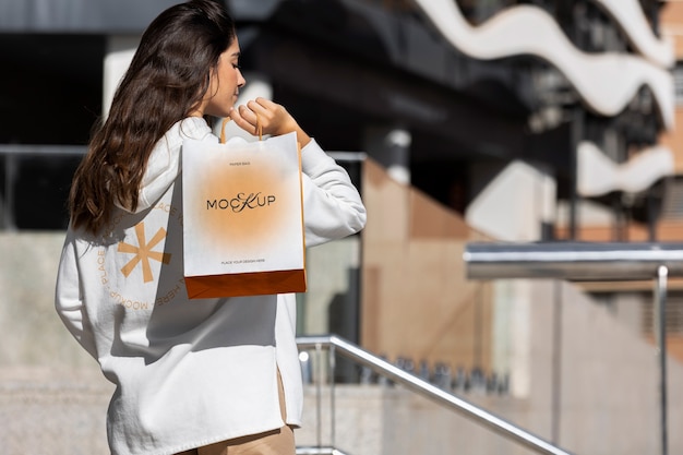 PSD woman holding shopping bag outdoors on the street