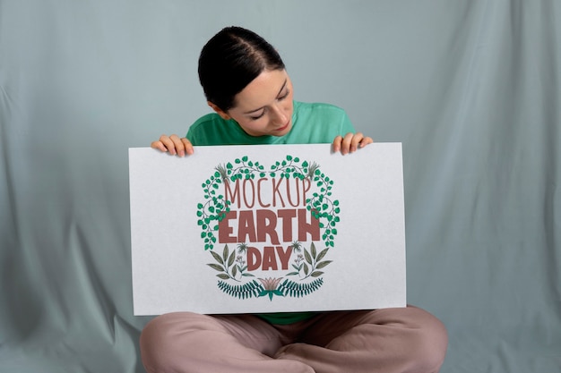 PSD woman holding signboard mock-up for earth day