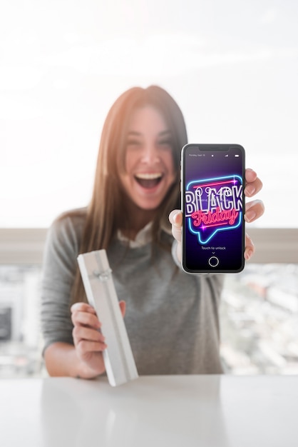 PSD woman holding smartphone mockup with black friday concept