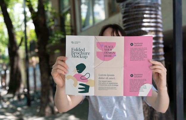 Mock-up di brochure a tre ante della holding della donna con forme astratte