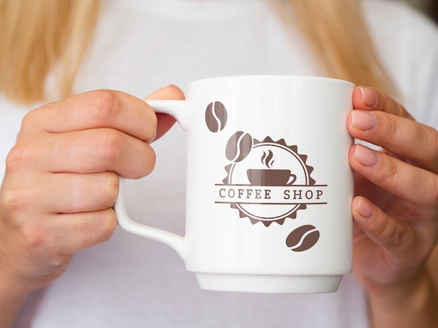 PSD woman holding up a coffee mug mock-up