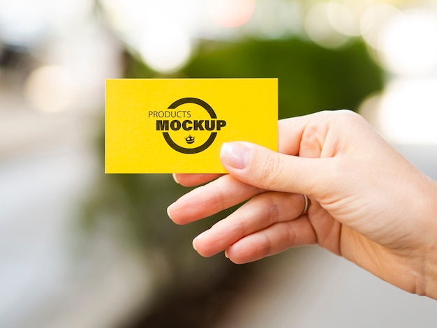 Woman holding up a yellow business card