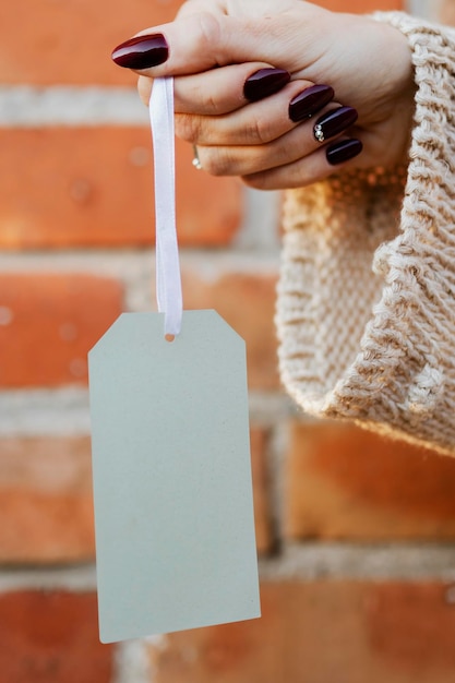 PSD woman holding a white tag mockup