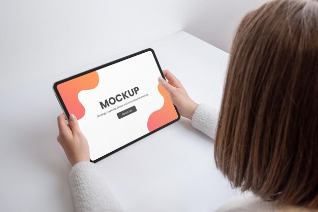 Woman holds tablet on workdesk mockup