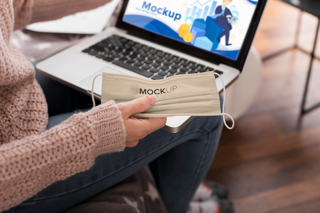 Woman at home with mask and laptop mock-up