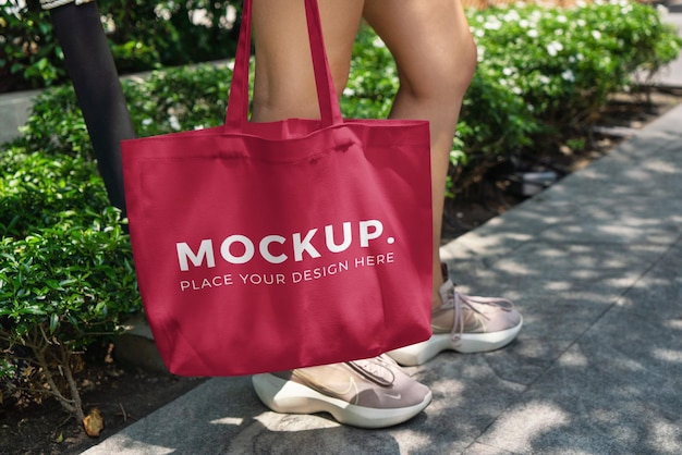 A woman is holding a tote bag mockup