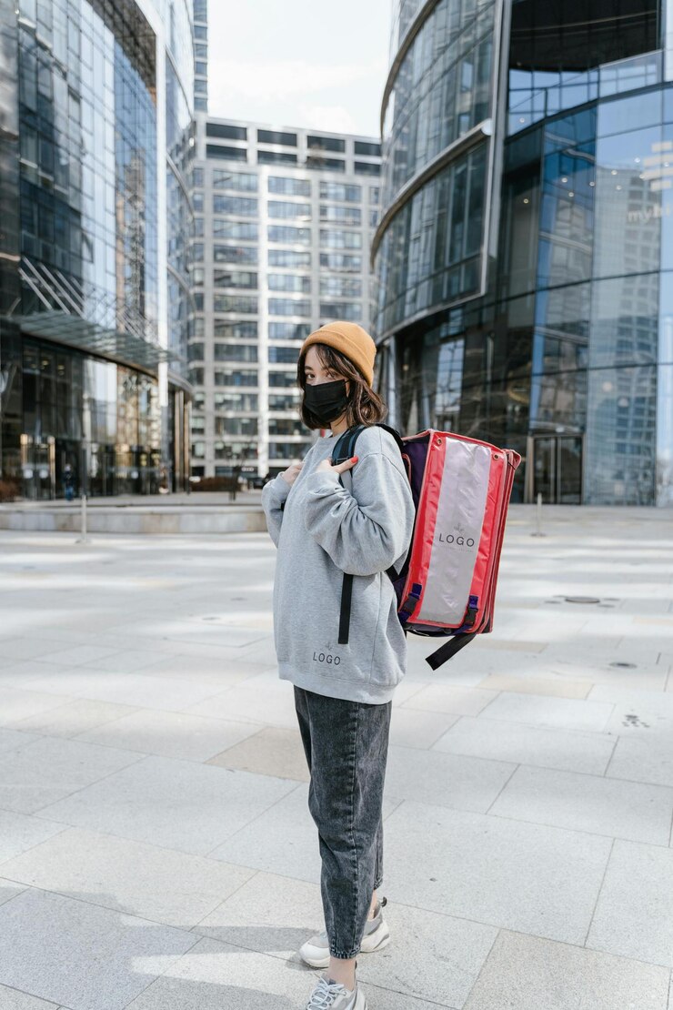 PSD a woman is walking on a sidewalk with a red and black bag