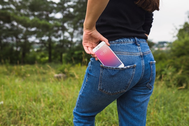 PSD woman in nature with smartphone in pocket