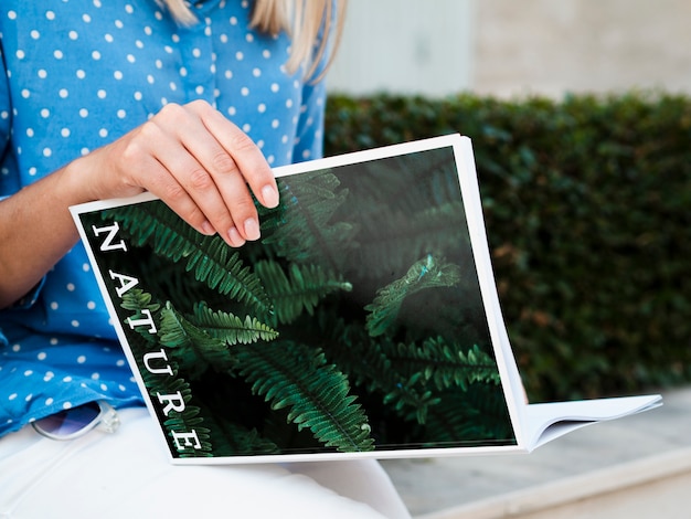 Woman outdoor reading magazine