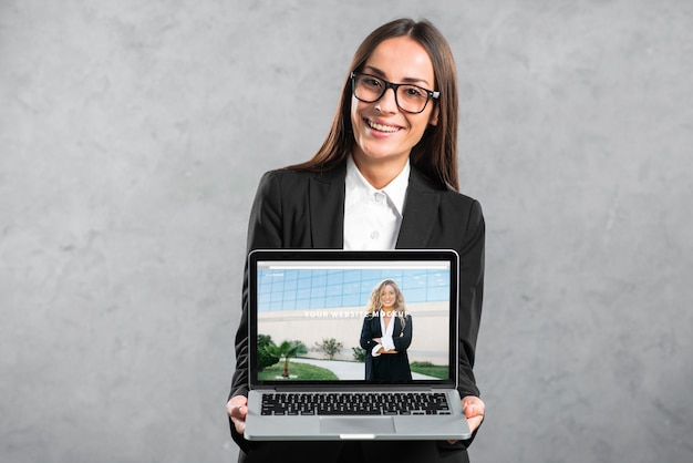 PSD woman presenting laptop mockup