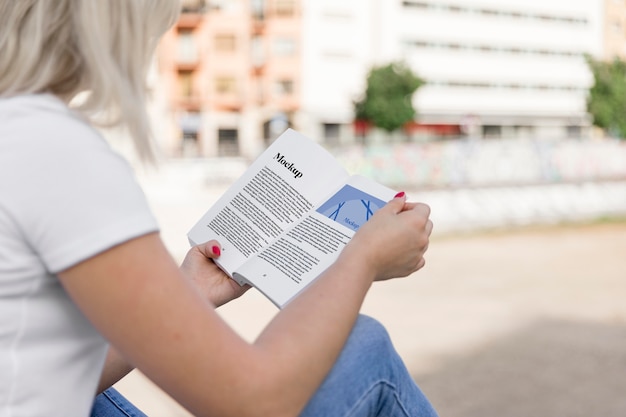 通りで本を読んでいる女性のクローズアップ