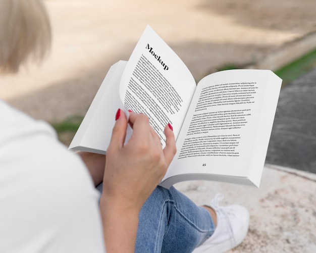 Woman reading book on street close up