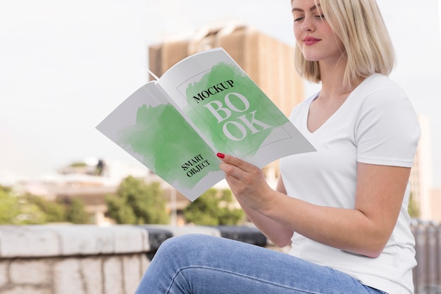 Woman reading book on street