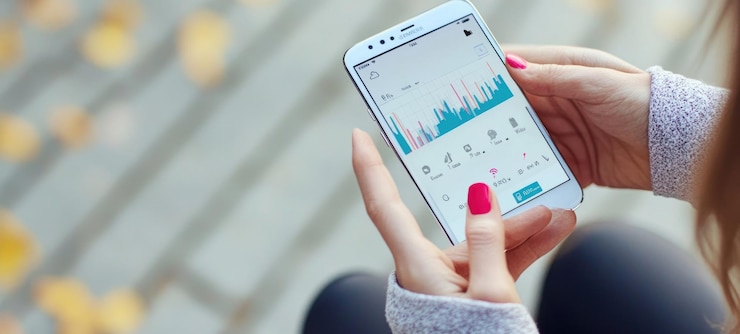 PSD woman reviewing fitness data on her smartphone outdoors