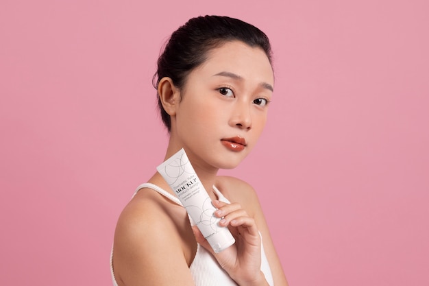 Woman showing face cream for skincare and beauty