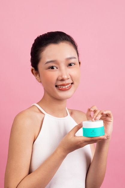 Woman showing face cream for skincare and beauty