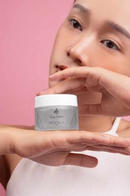 Woman showing face cream for skincare and beauty