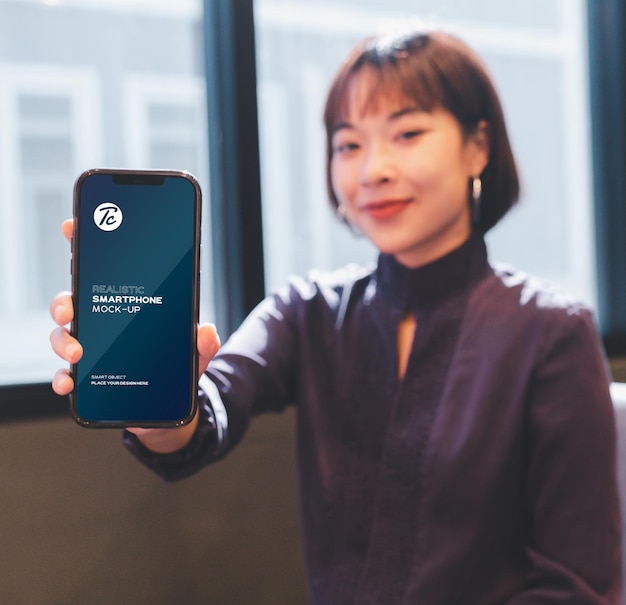 Woman showing her smartphone screen mockup in cafe