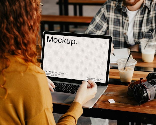 a woman uses a laptop in a cafe