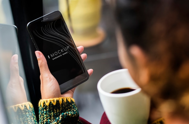 PSD woman using a mobile phone mockup in a coffee shop