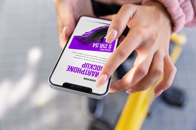 PSD donna che utilizza lo smartphone mock-up all'aperto mentre è in bicicletta