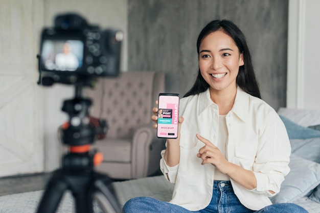 Vlogger donna che tiene un modello di telefono