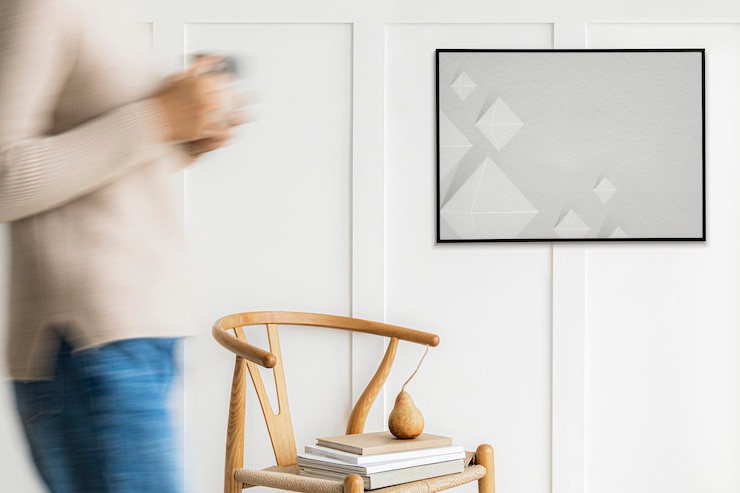PSD woman walking past a black photo frame on a white wall mockup