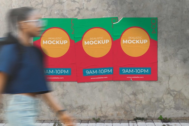 Woman walks in front of 3 realistic posters mockup sticks on concrete wall surface psd