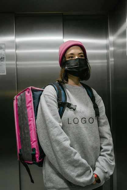 a woman wearing a grey sweatshirt with the word logo on it