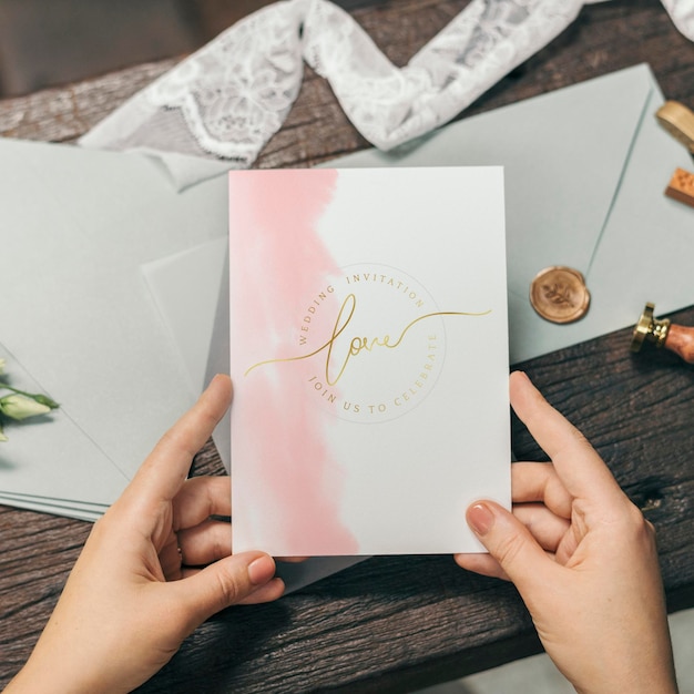 結婚式の招待カードのモックアップを持つ女性