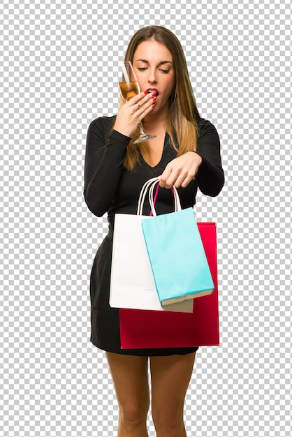 Woman with champagne celebrating new year 2019 surprised while holding a lot of shopping bags