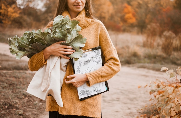 Woman with clipboard mockup and flowers