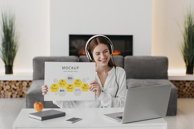 Woman with headphones holding paper sheet