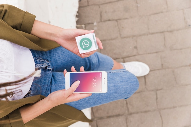 Woman with smartphone and whatsapp cube