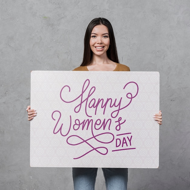 woman with wide smile holding a placard