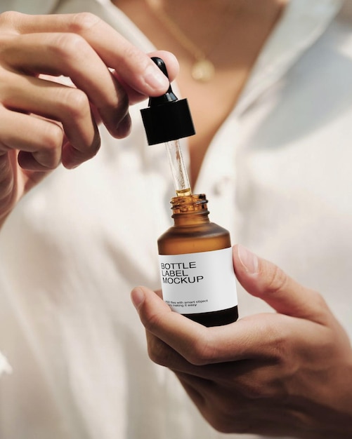 A women holding the dropper bottle with label mockup