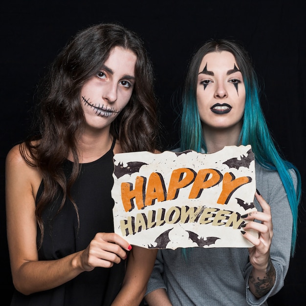 Women holding paper with halloween lettering