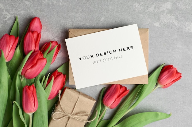 Макет поздравительной открытки на женский день с подарочной коробкой и цветами красных тюльпанов