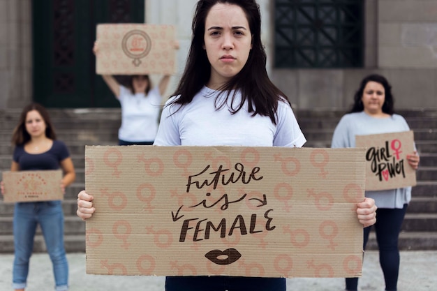 Womens holding cartoon board with message