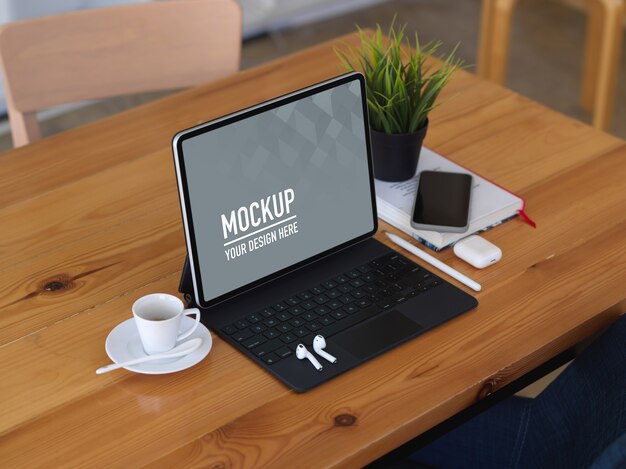 Wooden table with digital tablet mockup, coffee cup, smartphone and accessories