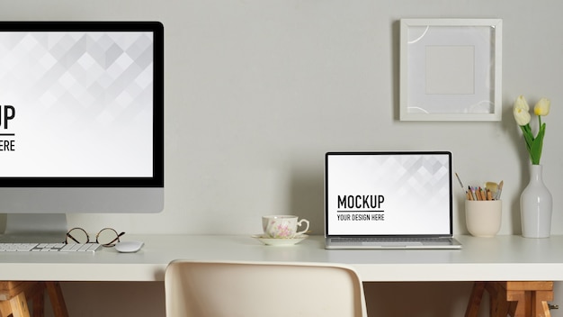 Workspace with laptop and desktop mockup, books and stationery