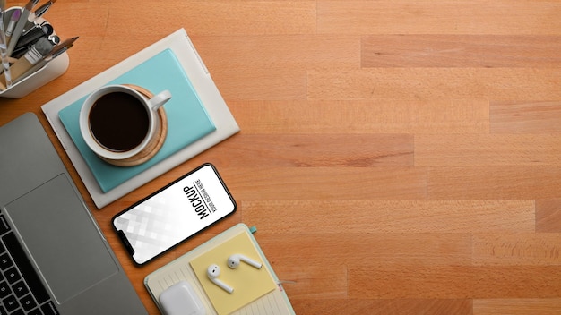 Workspace with smartphone, laptop, coffee cup, stationery and copy space