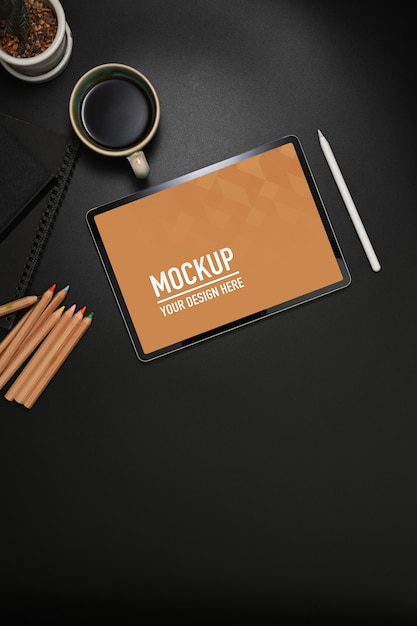 Workspace with tablet mockup, coloured pencils and coffee cup