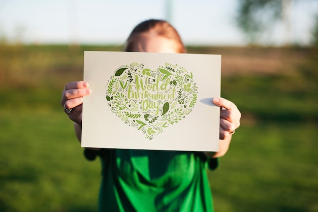 World environment day mockup with volunteer holding paper