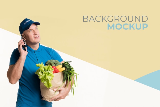 PSD worried delivery man holding a box with different vegetables