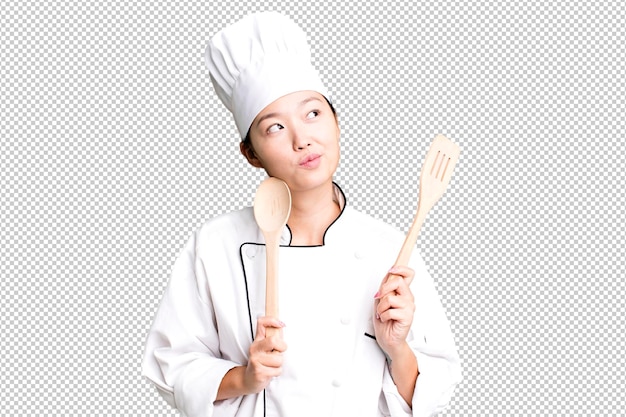 young adult pretty asian woman restaurant chef with a wooden tool