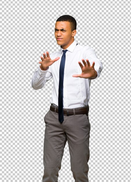 Young afro american businessman is a little bit nervous and scared stretching hands to the front